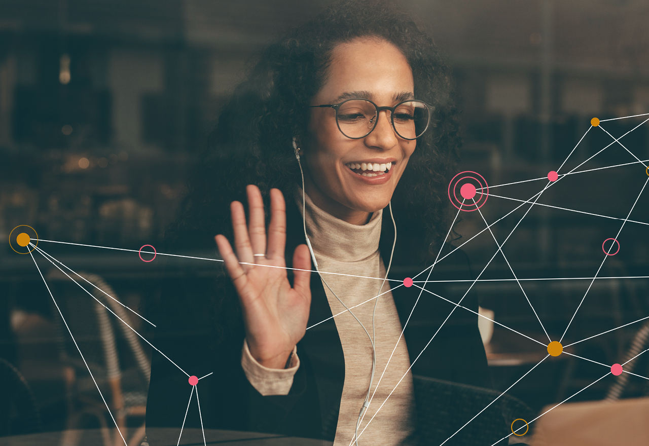 A woman with earphones waving at her screen surrounded by colourful dot graphic/texture